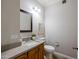 A traditional bathroom features a single sink vanity, toilet, updated light fixture and framed mirror at 902 W Glendale Ave # 115, Phoenix, AZ 85021