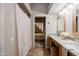 Bright bathroom with double sinks and a shower/tub with curtains for privacy and a bedroom in the background at 902 W Glendale Ave # 115, Phoenix, AZ 85021