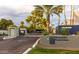 Palisades Racquet Estates entrance featuring lush landscaping, mature palms, and covered parking at 902 W Glendale Ave # 115, Phoenix, AZ 85021