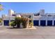 View of condominiums with blue doors, bougainvillea and palm trees at 902 W Glendale Ave # 115, Phoenix, AZ 85021