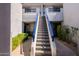 View of a condo with blue banister stairs and desert landscaping at 902 W Glendale Ave # 115, Phoenix, AZ 85021