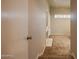 Hallway featuring neutral carpeting and paint leads into a bright living area with fireplace and shuttered windows at 902 W Glendale Ave # 115, Phoenix, AZ 85021