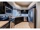 Modern kitchen featuring stainless steel appliances, and dark cabinetry at 902 W Glendale Ave # 115, Phoenix, AZ 85021