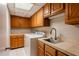 Bright laundry room featuring overhead cabinets, ample counter space, a laundry sink, and a washer and dryer at 902 W Glendale Ave # 115, Phoenix, AZ 85021
