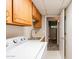 Bright laundry room featuring overhead cabinets, ample counter space, a laundry sink, and a washer and dryer at 902 W Glendale Ave # 115, Phoenix, AZ 85021