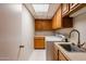 Bright laundry room featuring overhead cabinets, ample counter space, a laundry sink, and a washer and dryer at 902 W Glendale Ave # 115, Phoenix, AZ 85021