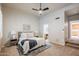 Bright main bedroom featuring a ceiling fan, an ensuite bathroom, and stairs to another level at 902 W Glendale Ave # 115, Phoenix, AZ 85021