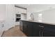 Open concept kitchen with a dark island, stainless appliances, and modern cabinets at 1127 E Mcneil St, Phoenix, AZ 85042