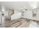Open-concept living room featuring modern gray wood floors, neutral walls, and bright windows at 1227 W Avalon Canyon Dr, Casa Grande, AZ 85122