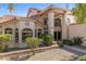 Inviting two-story home showcasing stucco exterior, tile roof, arched windows, and manicured landscaping at 1327 E Le Marche Ave, Phoenix, AZ 85022