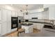Bright kitchen with white cabinetry, island, tiled floor, and stainless steel appliances at 1327 E Le Marche Ave, Phoenix, AZ 85022