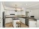 Kitchen with white cabinets, tiled flooring, island with stool seating, and stainless steel appliances at 1327 E Le Marche Ave, Phoenix, AZ 85022