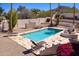 Backyard pool features stone patio, lounge chairs, and a decorative fireplace with bright bougainvillea in a desert landscape at 1327 E Le Marche Ave, Phoenix, AZ 85022