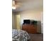 Bedroom featuring a dresser with a TV, ceiling fan, and an attached bathroom for convenience at 136 N 63Rd St, Mesa, AZ 85205