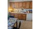 Cozy kitchen featuring wooden cabinets, white appliances, and a quaint dining area at 136 N 63Rd St, Mesa, AZ 85205
