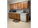 Traditional kitchen features wooden cabinets and white appliances offering functionality and ample storage space at 136 N 63Rd St, Mesa, AZ 85205