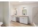 This primary bathroom offers double sinks, modern lighting, a walk-in shower, and sleek, light-colored cabinets at 13802 N 186Th Ave, Surprise, AZ 85388