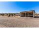 Spacious property featuring a home and large carport/storage building, set in a desert landscape offering ample space and utility at 13802 N 186Th Ave, Surprise, AZ 85388
