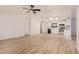 Spacious living area featuring hardwood floors, modern fan, kitchen, and natural light, blending comfort and contemporary design at 13802 N 186Th Ave, Surprise, AZ 85388