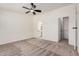 The spacious main bedroom features plush carpet, a ceiling fan, and access to the ensuite bathroom at 13802 N 186Th Ave, Surprise, AZ 85388