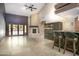 Open living room featuring a grand fireplace, high ceilings, and a stylish bar area for entertaining at 1530 E Jeanine Dr, Tempe, AZ 85284