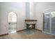 Bright living room featuring a stone fireplace, carpeted floors, and access to an adjacent room at 1530 E Jeanine Dr, Tempe, AZ 85284