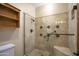 Elegant tiled shower features glass door, handrails, a built-in seat, and a showerhead at 1530 E Jeanine Dr, Tempe, AZ 85284