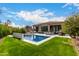 Inviting backyard pool with lush green grass and outdoor lounging area at 16013 N 111Th Pl, Scottsdale, AZ 85255