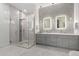 Elegant bathroom with glass shower, double sinks, decorative tile accent wall, and modern pendant lights at 16013 N 111Th Pl, Scottsdale, AZ 85255