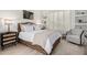 Bright bedroom with a woven platform bed, neutral decor, shuttered windows, and a comfortable sitting chair at 16013 N 111Th Pl, Scottsdale, AZ 85255