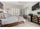 Bright bedroom featuring built-in shelving, shuttered windows, mirrored closet, and modern furniture at 16013 N 111Th Pl, Scottsdale, AZ 85255