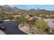 An exquisite home sits in a desert landscape with mountain views, featuring lush landscaping and a circular driveway at 16013 N 111Th Pl, Scottsdale, AZ 85255