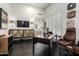 Contemporary home office with black desk, wooden accents, large shuttered window, and decorative wall art at 16013 N 111Th Pl, Scottsdale, AZ 85255
