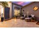 Cozy outdoor patio featuring tiled floors, comfortable seating, and ambient lighting for relaxed evenings at 16013 N 111Th Pl, Scottsdale, AZ 85255