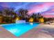 Capture the essence of backyard bliss with a pristine pool and gentle waterfall, set amidst desert landscaping under the twilight sky at 16013 N 111Th Pl, Scottsdale, AZ 85255