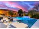 A refreshing pool with a water feature is the focal point of a backyard with seating, dining, and a mountain view at 16013 N 111Th Pl, Scottsdale, AZ 85255