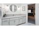 Elegant bathroom with a vanity, round mirror, modern lighting, and a doorway to a home theatre at 1721 E Hatcher Dr, Phoenix, AZ 85020