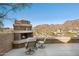 A cozy outdoor space with a fireplace and chairs offers stunning views of the city and mountains at 1721 E Hatcher Dr, Phoenix, AZ 85020