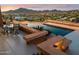 Stunning infinity pool with city views, lounge chairs, and ambient lighting create a relaxing outdoor oasis at 1721 E Hatcher Dr, Phoenix, AZ 85020