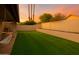 This backyard showcases a pristine lawn, complemented by lush greenery and a charming porch swing for relaxation at 17211 N 46Th Pl, Phoenix, AZ 85032