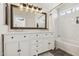 Bathroom with a double sink vanity, a bathtub, and tiled shower at 17211 N 46Th Pl, Phoenix, AZ 85032