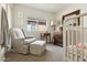 Cozy bedroom with a rocking chair, dresser, and a crib at 17211 N 46Th Pl, Phoenix, AZ 85032