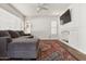 Living room with tile floors, a large grey couch, a ceiling fan and a TV at 17211 N 46Th Pl, Phoenix, AZ 85032