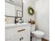 Stylish powder room featuring a modern vanity, a round mirror, and decorative accents for guests at 17211 N 46Th Pl, Phoenix, AZ 85032