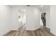 Open floor plan showcasing wood-look floors, white walls, stairs and an entrance to the kitchen at 17648 W Sanna St, Waddell, AZ 85355