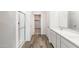 Bathroom boasts double sinks with quartz counters, white cabinets, and nearby walk-in shower and toilet areas at 17704 W Mission Ln, Waddell, AZ 85355
