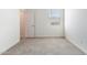 Cozy bedroom with a large window and neutral carpet and freshly painted white walls at 17704 W Mission Ln, Waddell, AZ 85355