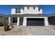 Two-story home with a dark garage door and well-maintained landscaping at 17704 W Mission Ln, Waddell, AZ 85355