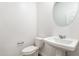 Half bathroom with pedestal sink, toilet, and chrome fixtures, and white walls at 17704 W Mission Ln, Waddell, AZ 85355
