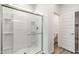Modern bathroom with a glass-enclosed shower and sleek white tile, next to a separate toilet area at 17704 W Mission Ln, Waddell, AZ 85355